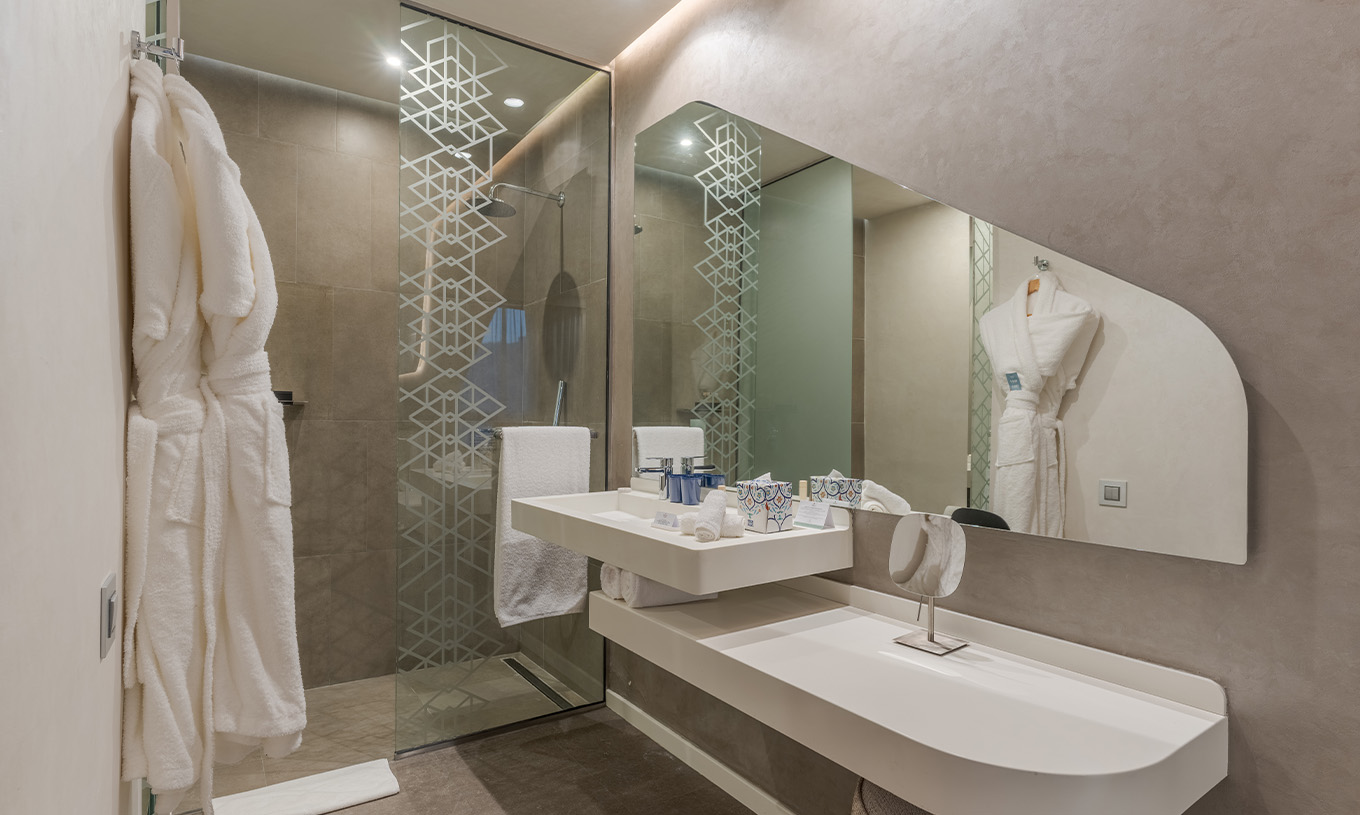 The CR7 Junior Suite Avenue at Pestana CR7 Marrakech has a bathroom with a sink, mirror, walk-in shower, and amenities