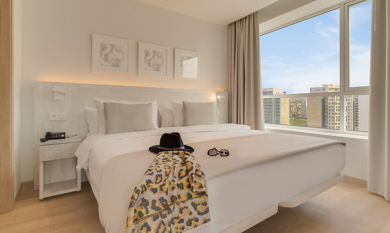The Premium Suite of Pestana Tanger City Center features a double bed with stone headboard, and a window with view