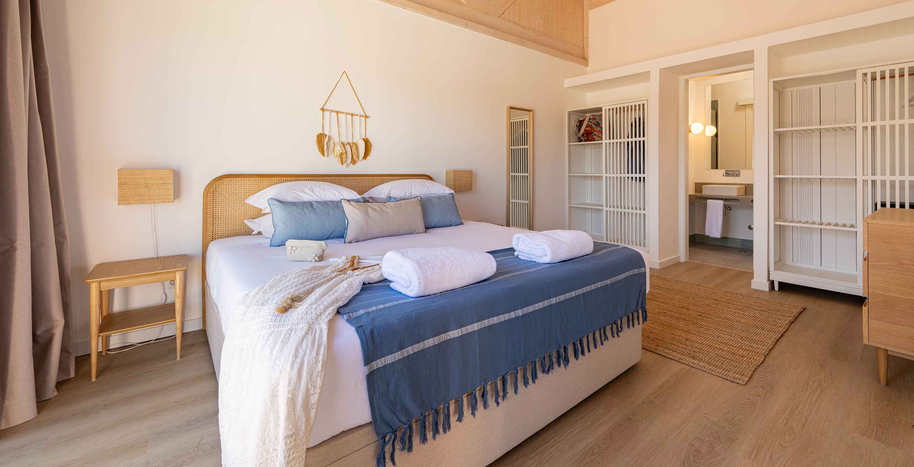 The Premium Green Villa at Pestana Comporta Village Residences has a bedroom with a double bed and several blue pillows