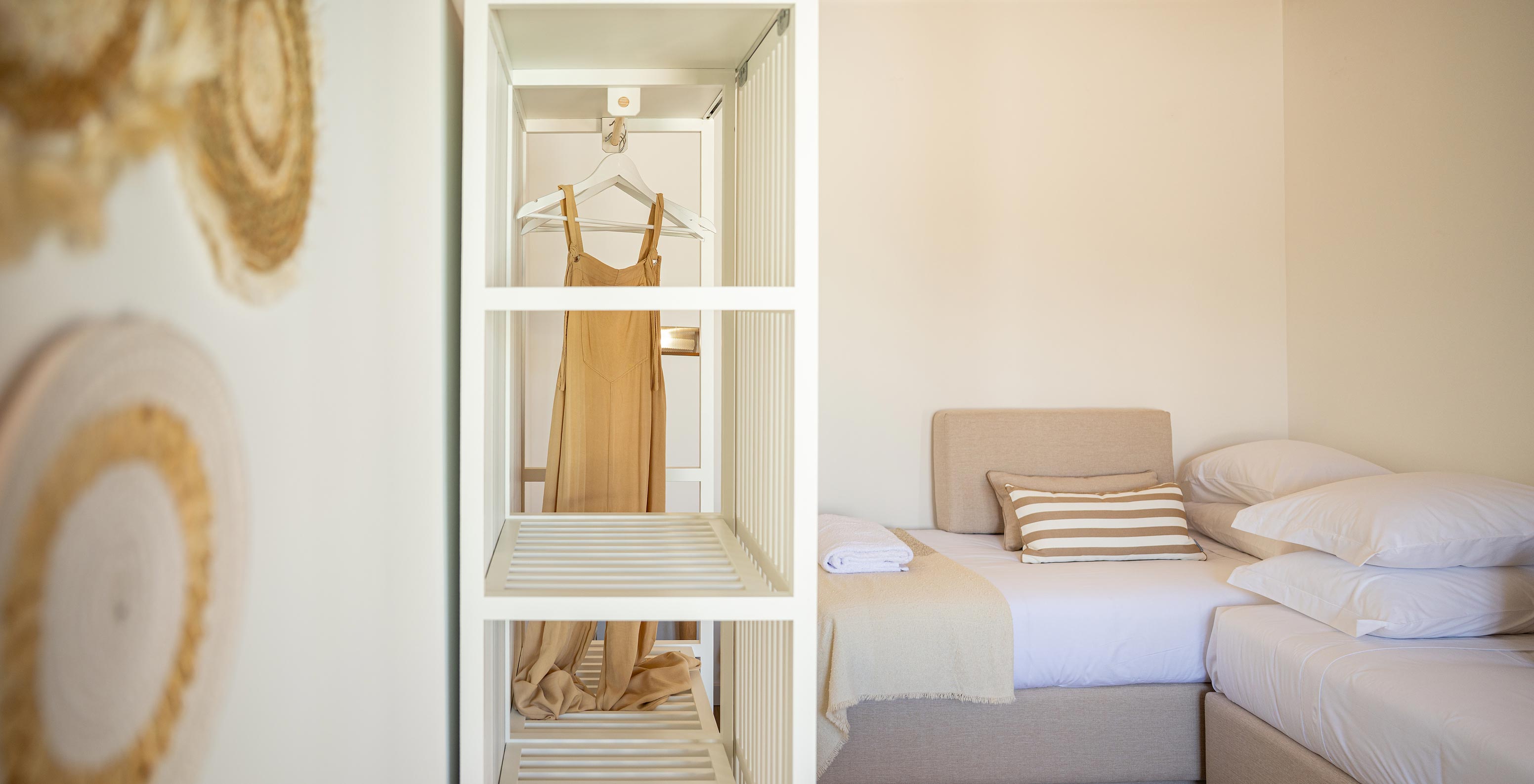 The Standard Villa at Pestana Comporta Village Residences has a closet with a white wardrobe and straw decoration