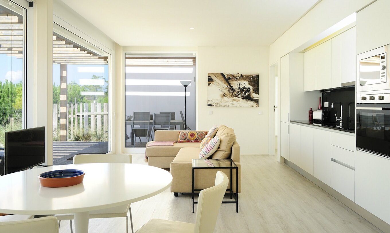 The Green T3 Villa of Pestana Tróia Eco Resort has a room combined with the kitchen, sofa, and dining table