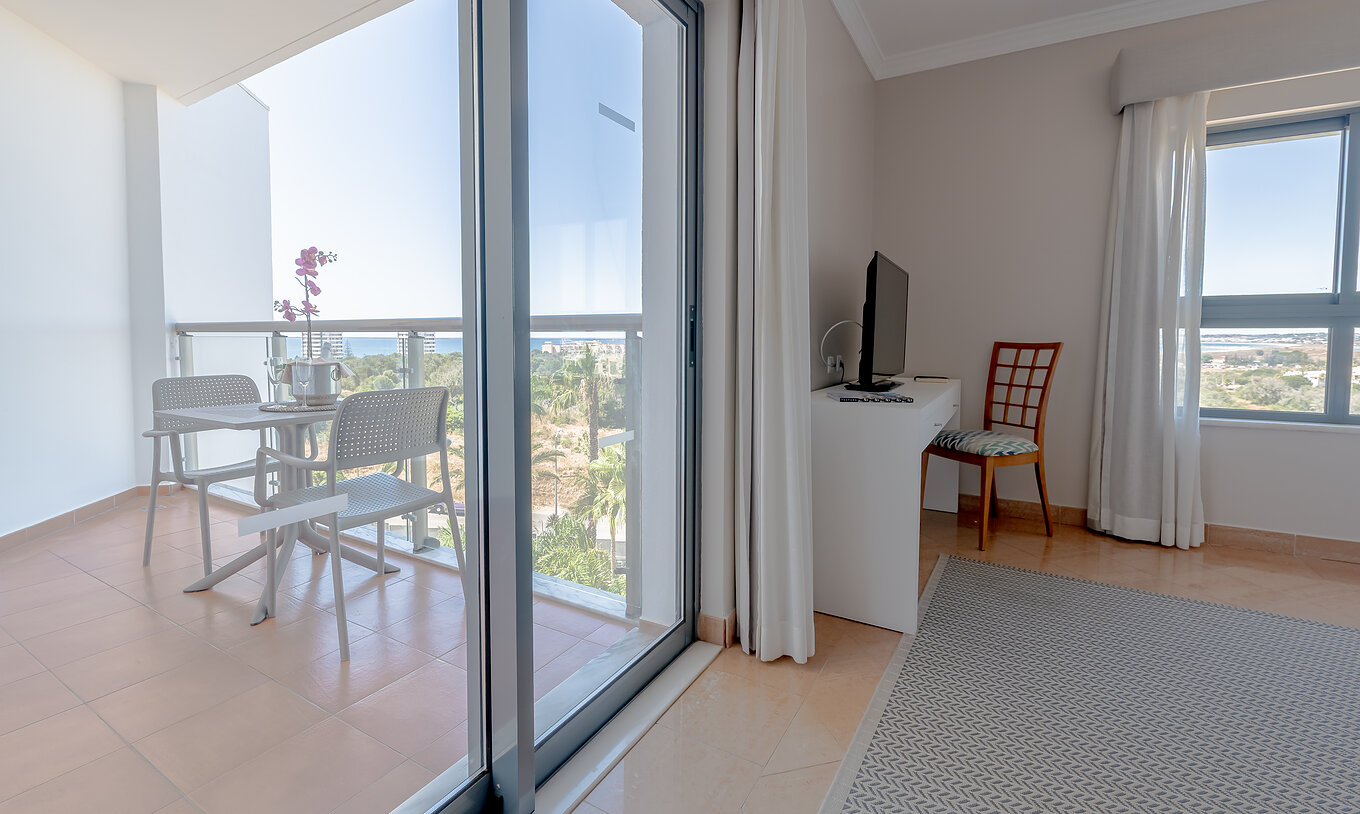 The T0 - Studio at Pestana Alvor Park has a balcony with a garden view and the sea in the background, with a table and chairs