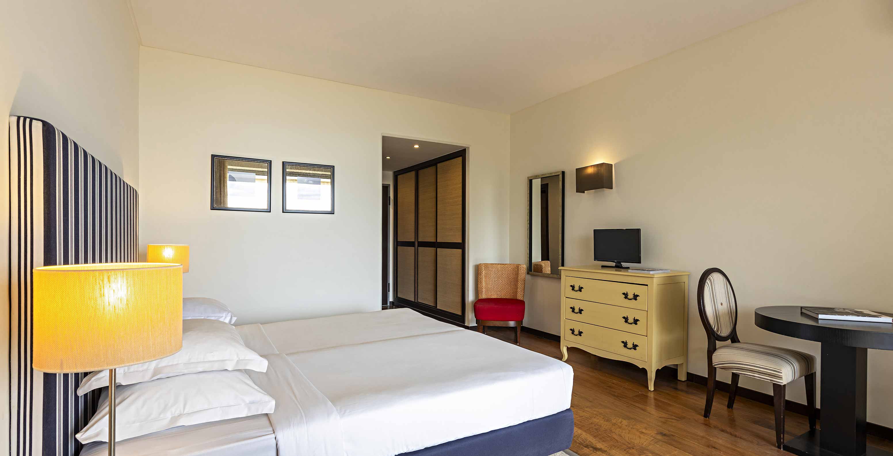 The Cliff Studio at Pestana Alvor Praia has a bedroom with a double bed, a TV, a mirror, and a wardrobe in the hallway