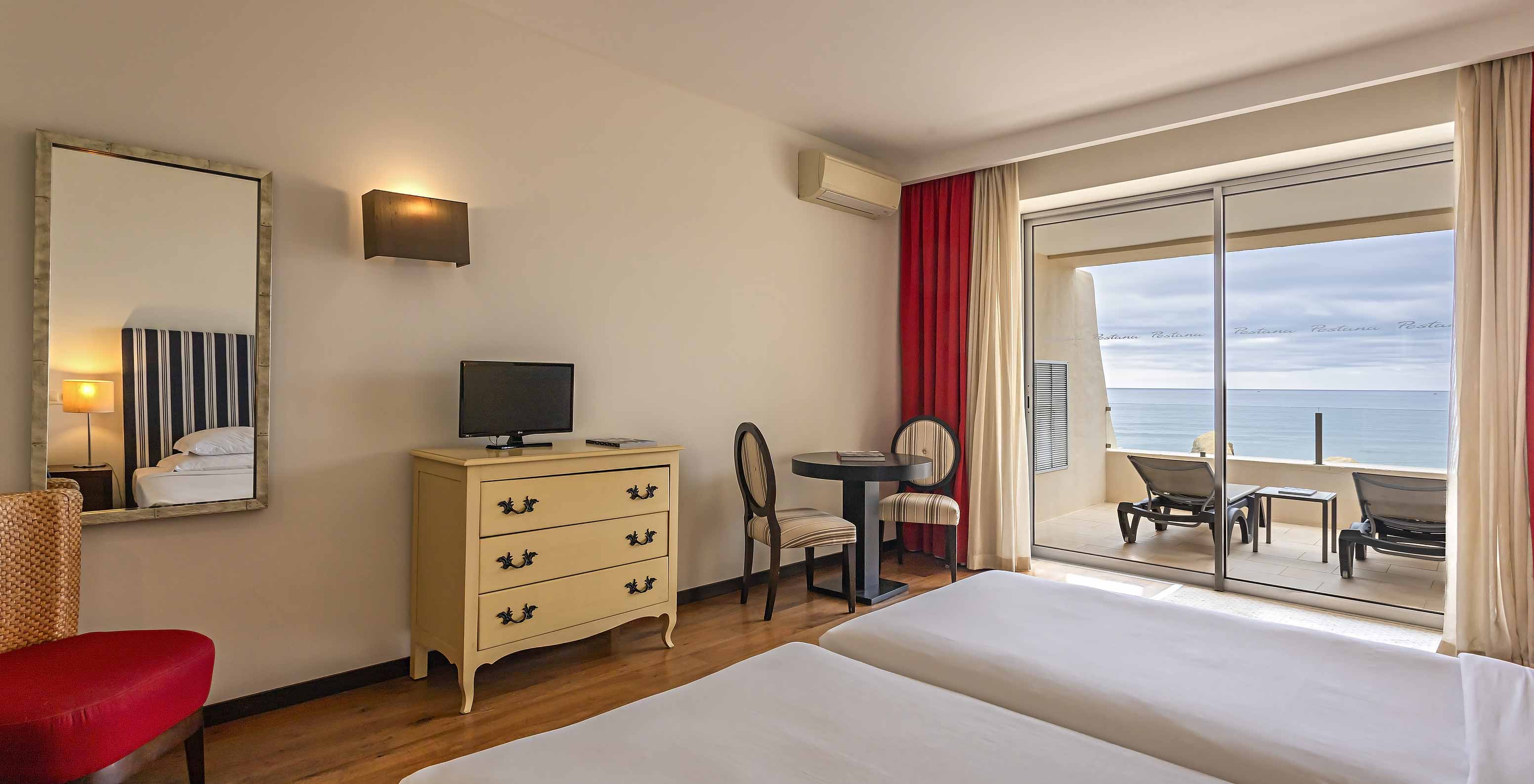 The Cliff Studio at Pestana Alvor Praia has a double bedroom with a dresser, a television, and a balcony with a sea view