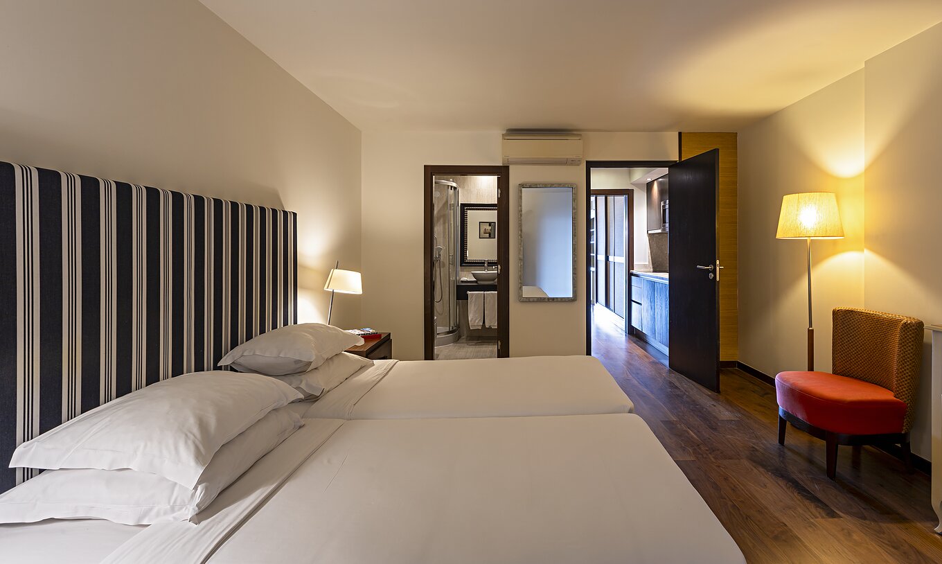 The Cliff Family at Pestana Alvor Praia has a double bedroom with a bathroom, a mirror, and air conditioning