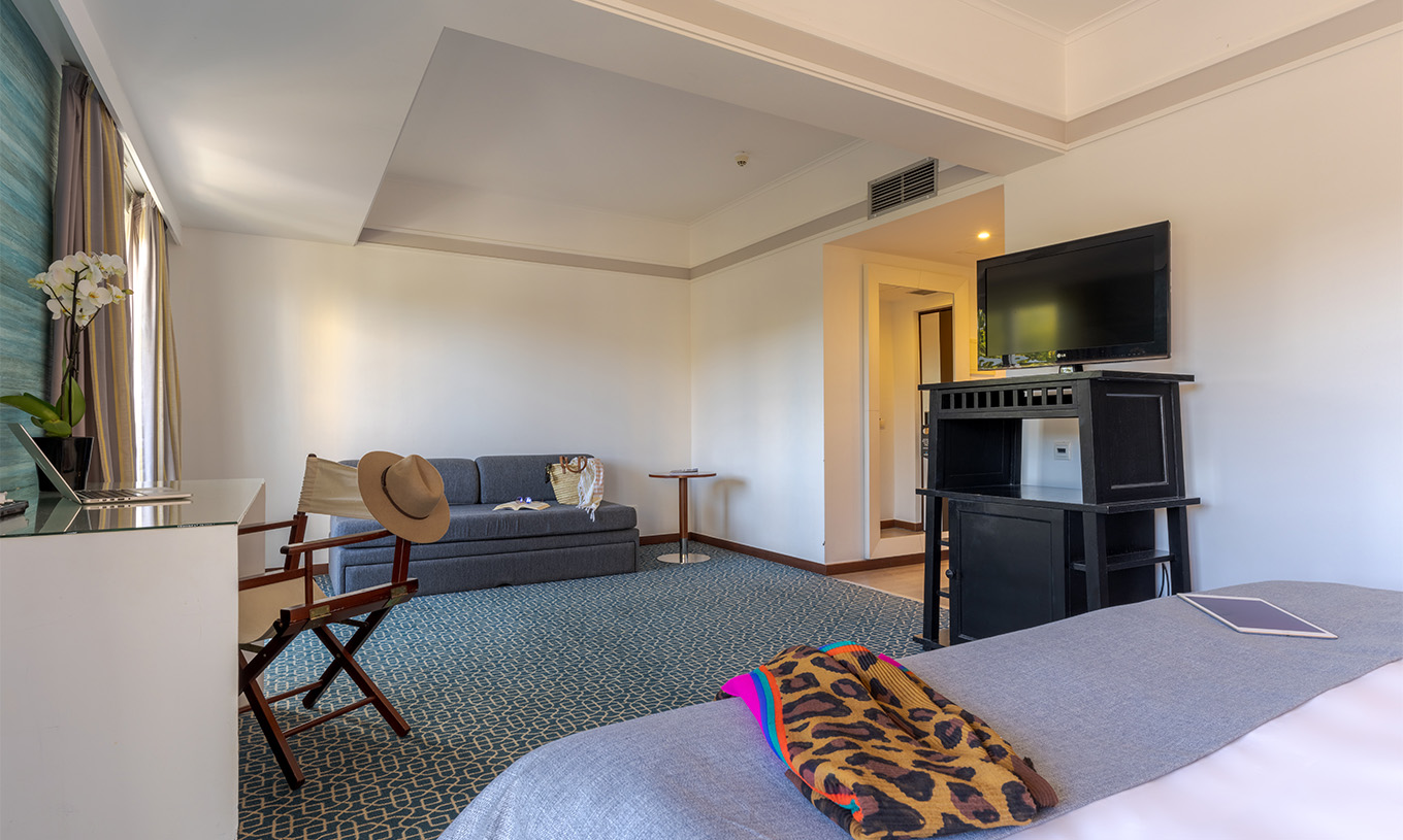 The Superior at Pestana Alvor Praia has a double bed, a black unit with TV, a sofa bed, and a desk