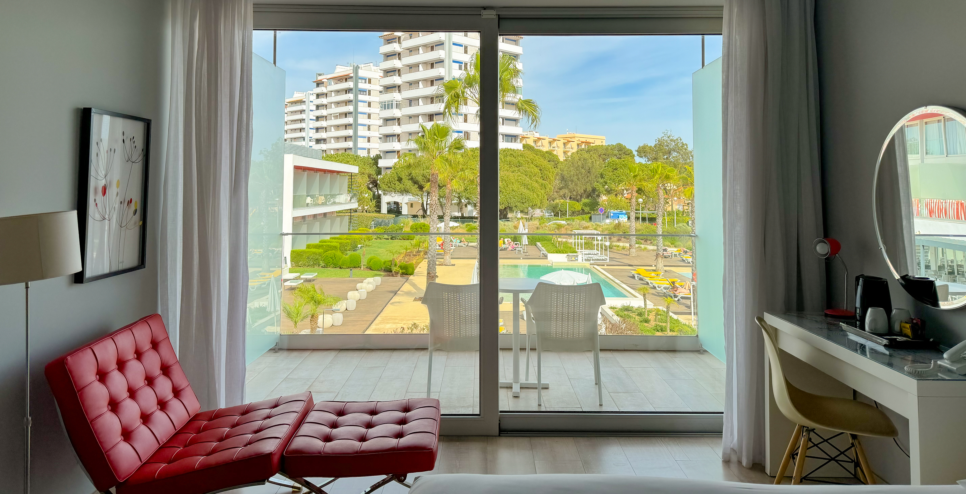 The Superior Deluxe Pool View of Pestana Alvor South Beach has a balcony with table and two chairs, and view of the pool