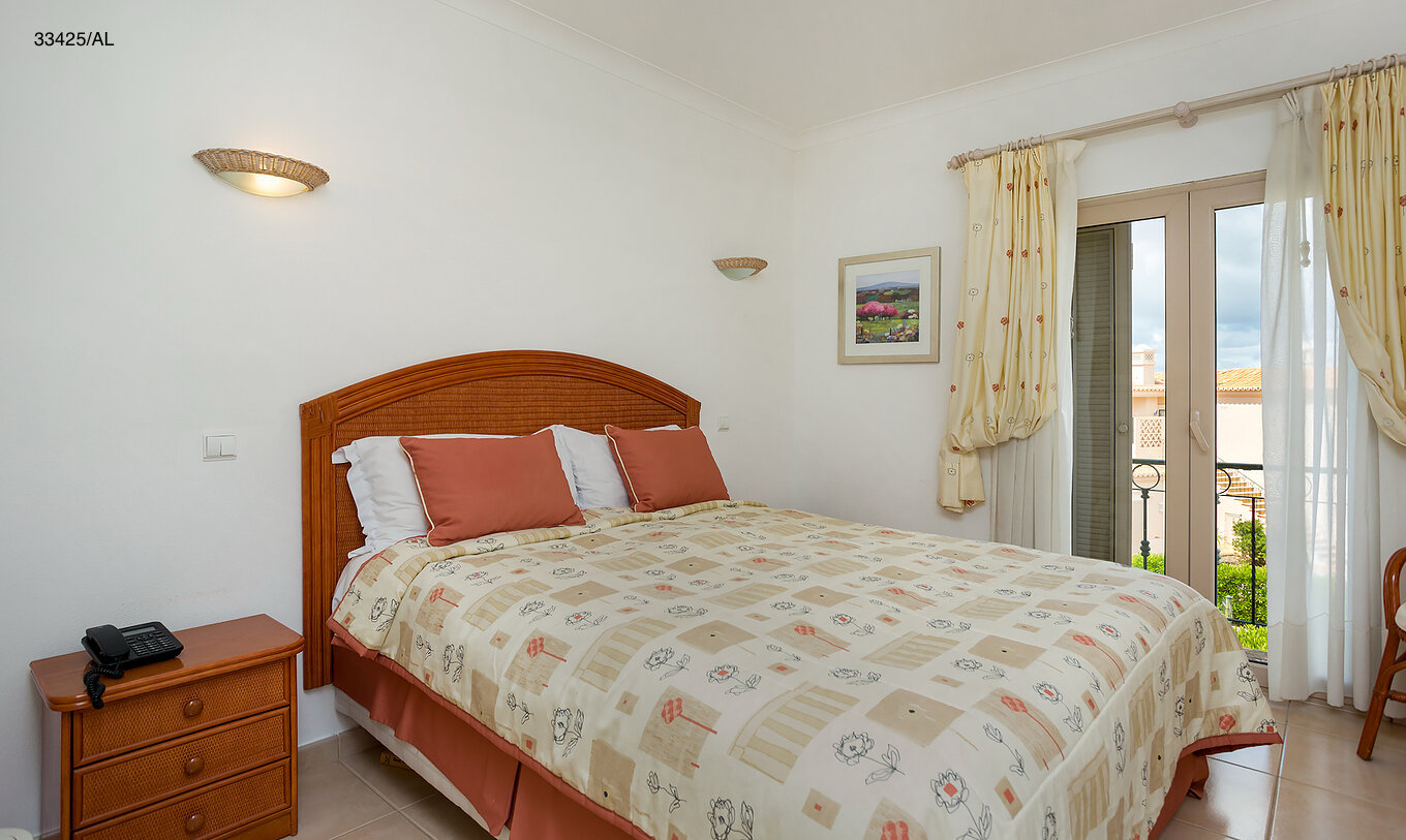 The Pestana Carvoeiro Golf T2 Standard Apartment has a bedroom with a double bed and two nightstands