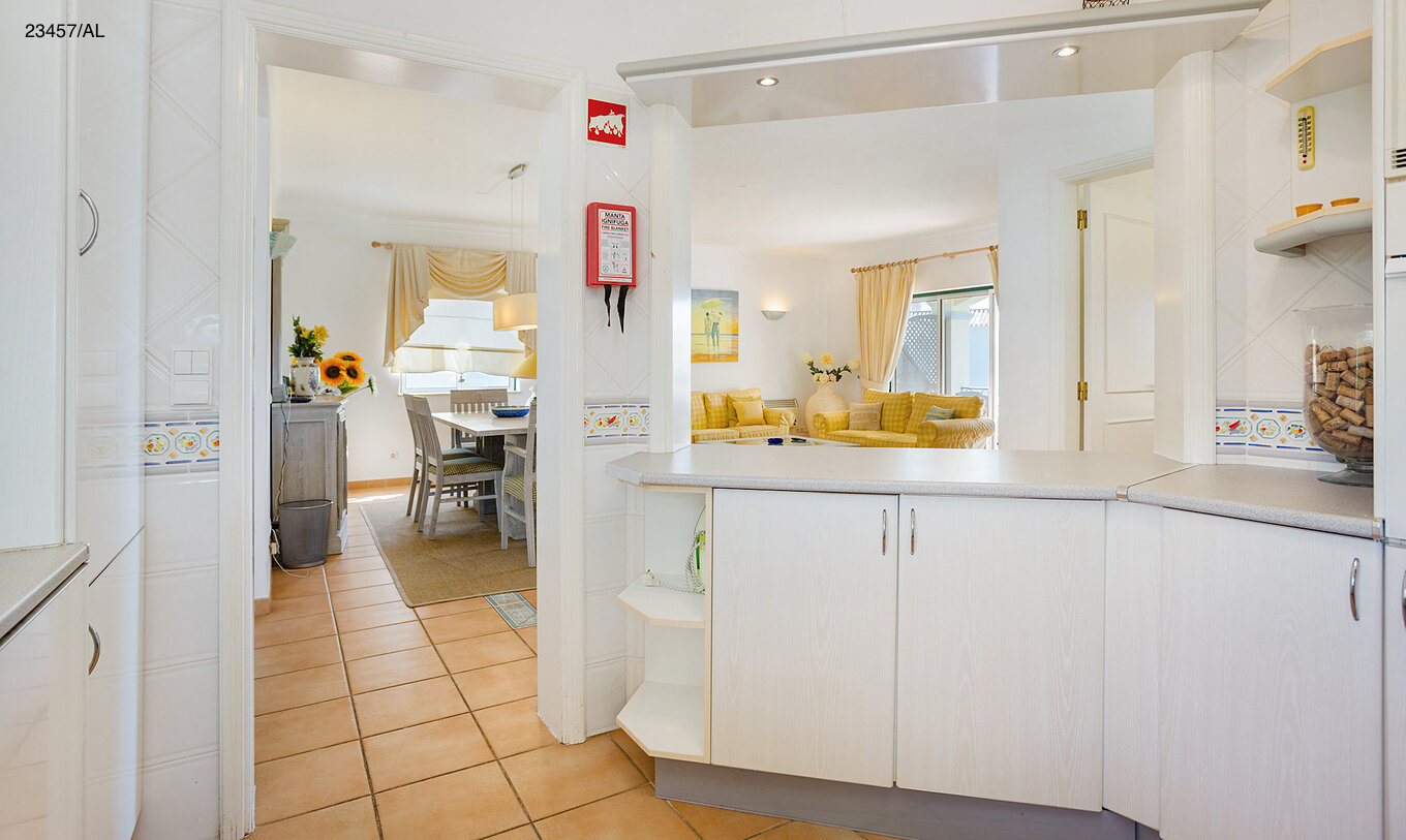 The Pestana Carvoeiro Golf T3 Standard Apartment has a kitchen with white cabinets and countertop open to the living room