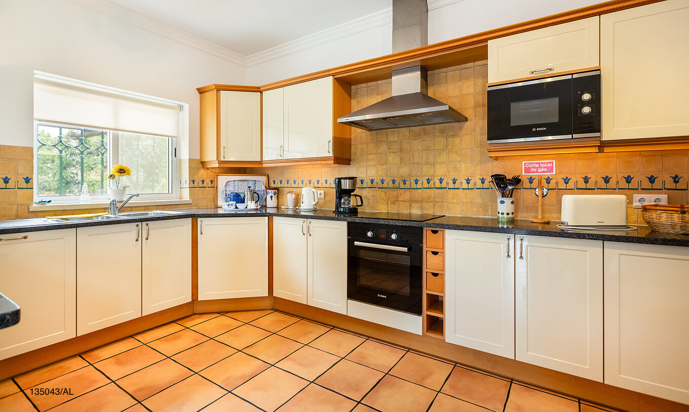 The Pestana Carvoeiro Golf V4 Standard Villa has a kitchen equipped with white cabinets and appliances