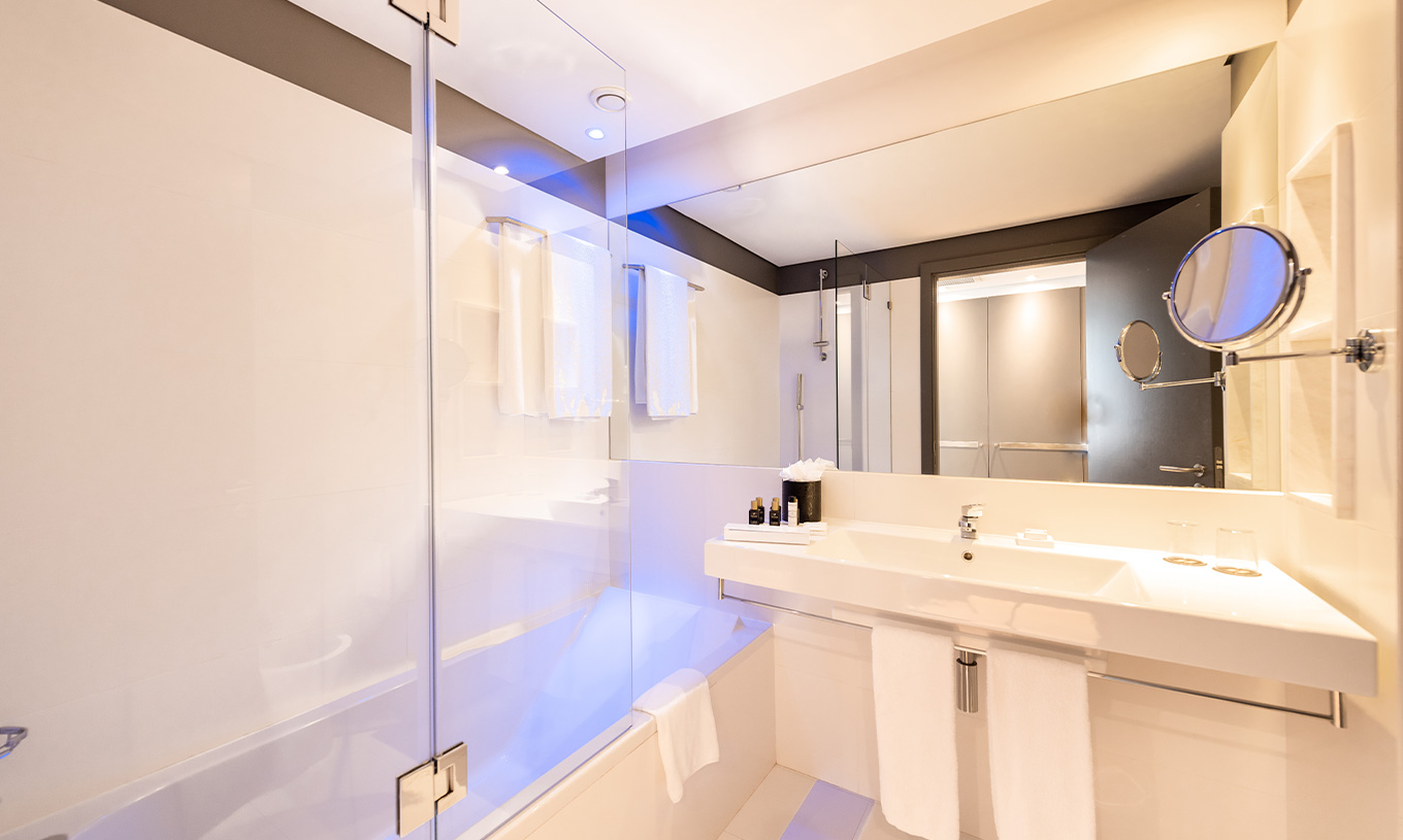 The Classic Room at Pestana Cidadela Cascais has a bathroom with a sink with a mirror and a bathtub with a shower