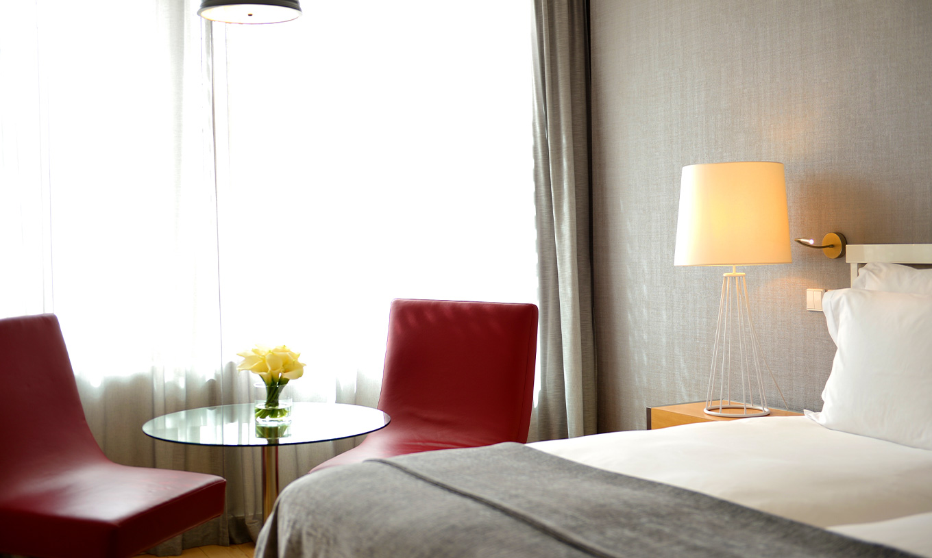 The Superior Room with Balcony at Pestana Cidadela Cascais has a double bed and a small table with a red chair