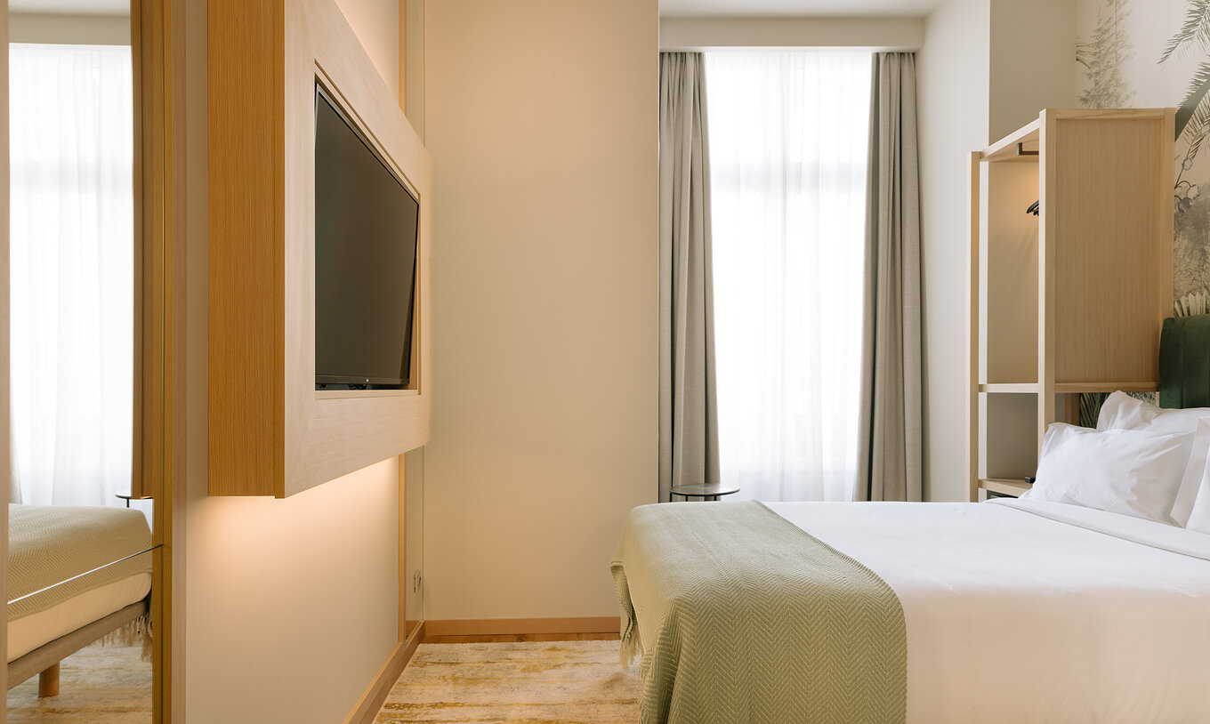 The Cozy Room at the Pestana Rua Augusta Lisbon has a double bed, TV and a window with curtains