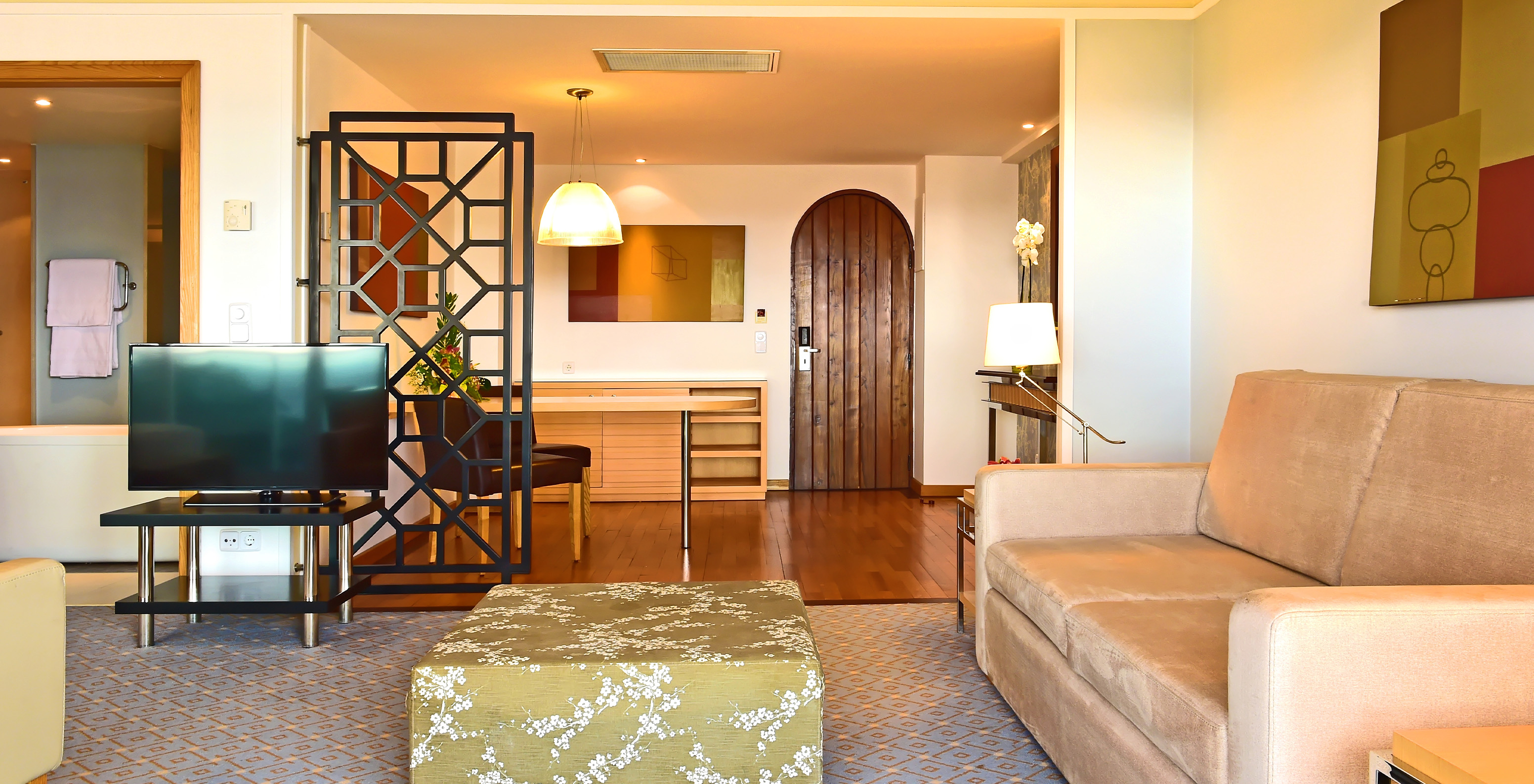 The Superior Junior Suite at Pestana Carlton Madeira has a living room with a sofa, TV, and an entrance area
