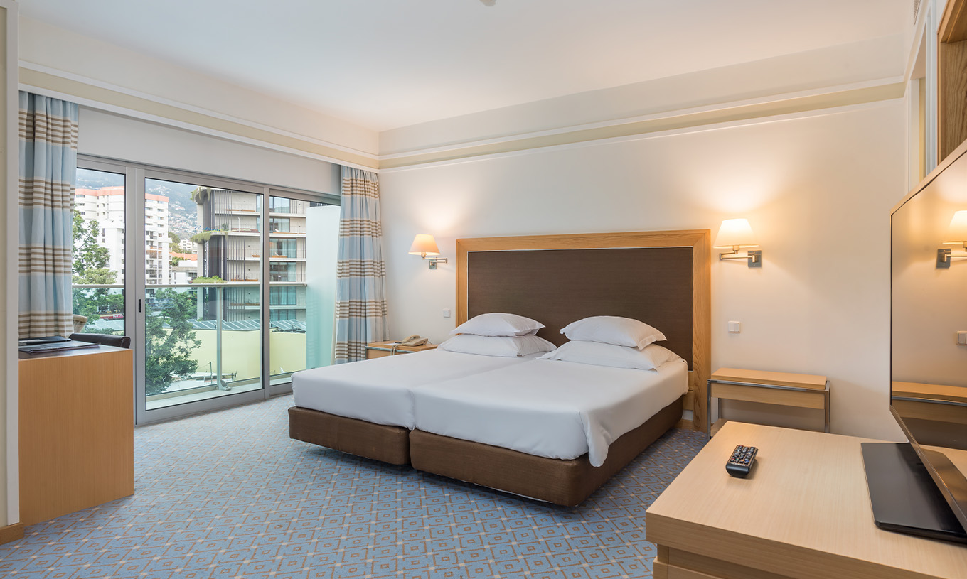 The Family Double Room at Pestana Carlton Madeira has a spacious area, a double bed, and a balcony