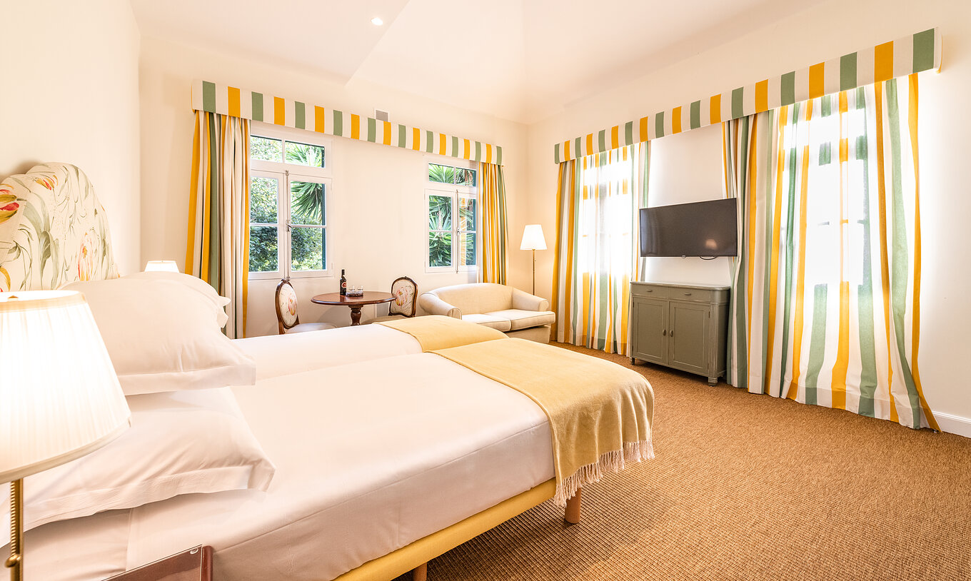 The Full Manor House of Pestana Quinta do Arco has two joined beds, sofa, table, television, carpet, and windows with curtains