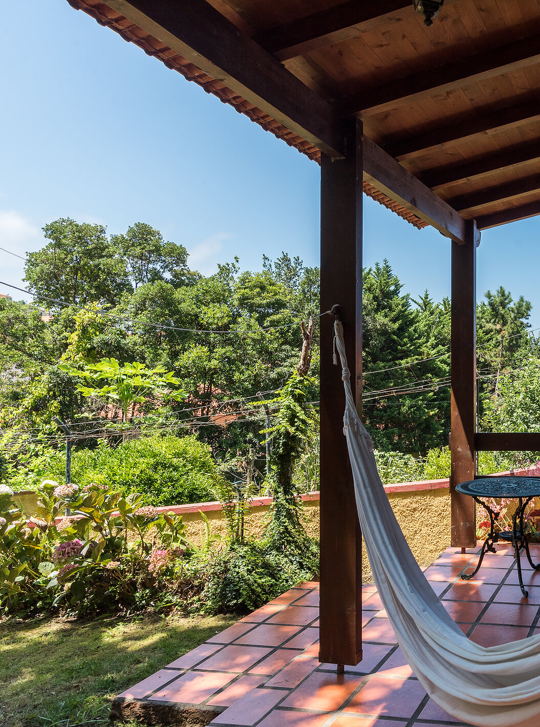 The Villas of Pestana Quinta do Arco have a hammock on the balcony, with chairs and a side table, and a view of the garden