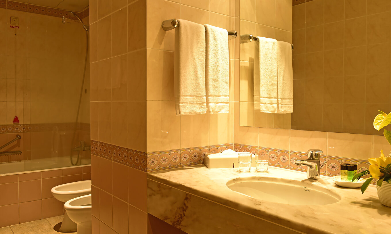 The Superior Family room at Pestana Village has a bathroom with toilet, bidet, sink with mirror and bathtub with shower
