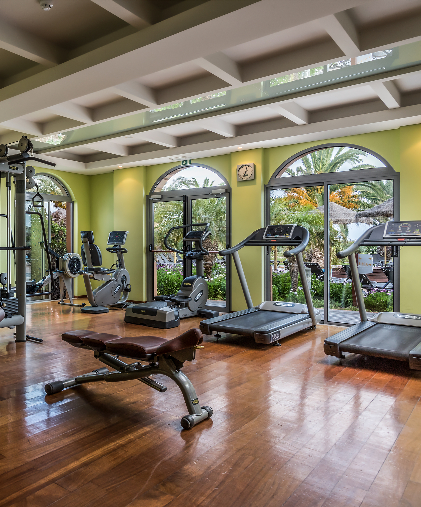 Gym with various machines like a bike with garden view windows at All Inclusive Hotel and Spa in Porto Santo