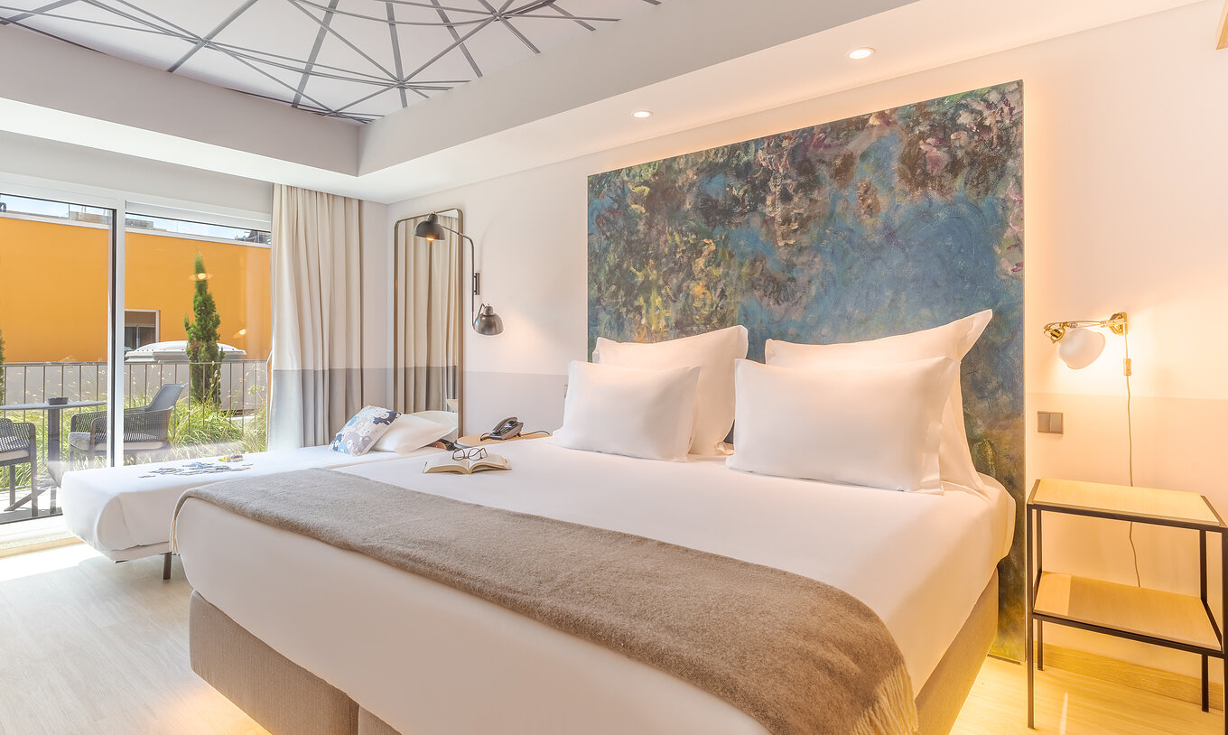 The Superior room at Pestana Douro Riverside has a double bed and a small bed, bedside table, and balcony