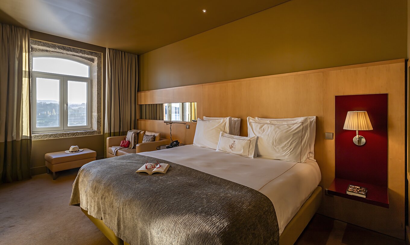 The Executive Superior has a double bed, a sofa, and a pouf by the window