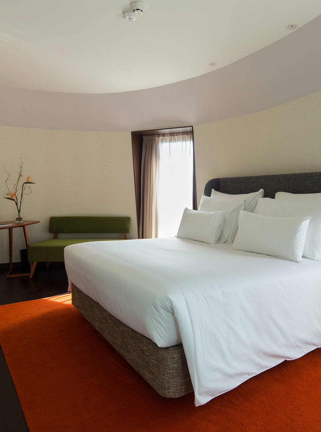 Panoramic View Signature at Pestana Porto - A Brasileira with king bed, wall TV and orange rug by tall windows