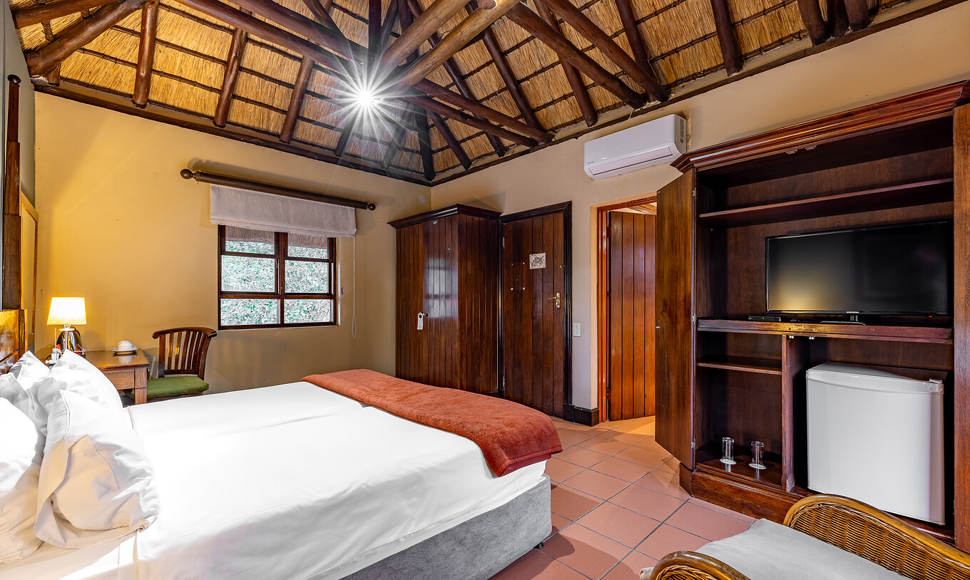The Standard Room at Pestana Kruger Lodge has two single beds, air conditioning, TV and wooden decor