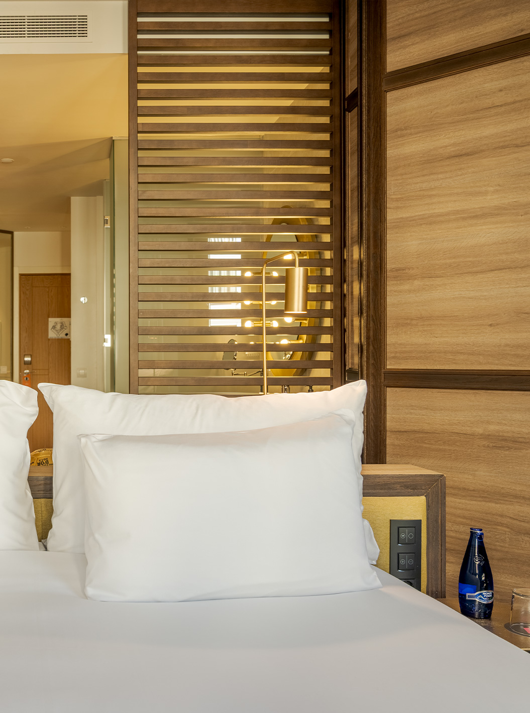 Deluxe Grand View at Pestana CR7 Gran Vía Madrid featuring white pillows beside warm wood panel lighting