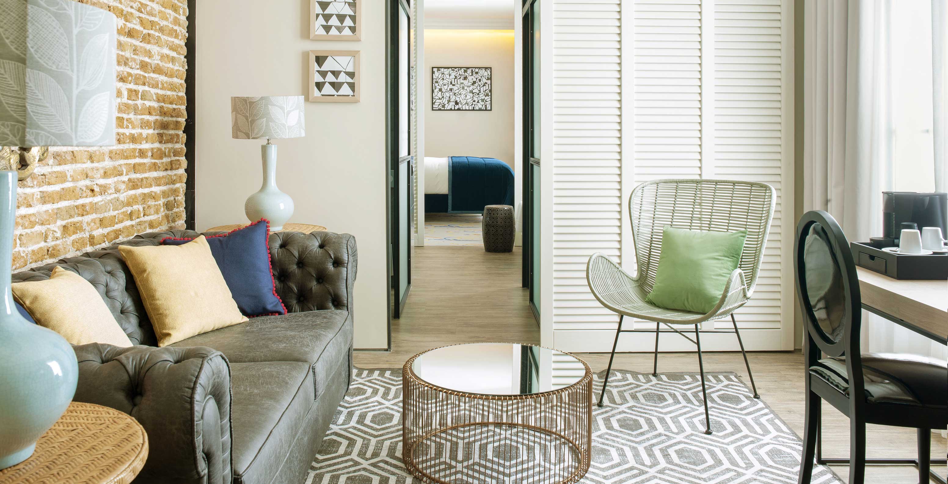 The Suite at Pestana Plaza Mayor has a separate living room with sofa, side tables with lamps and coffee machine