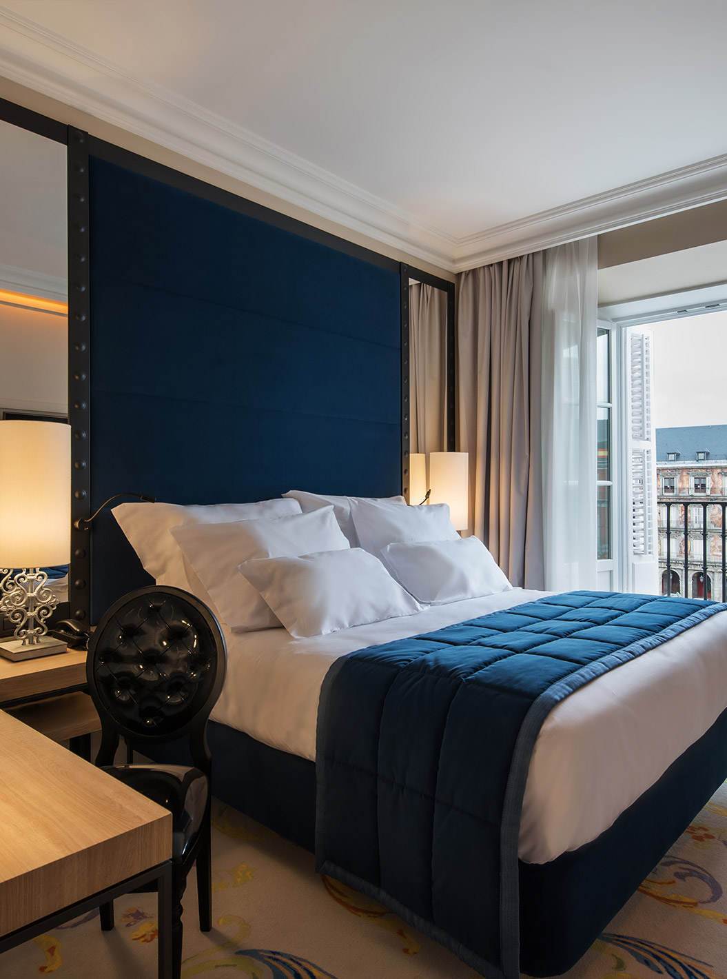 The Superior Plaza Mayor at Pestana Plaza Mayor Madrid has a bed, a lamp on the bedside table and a window