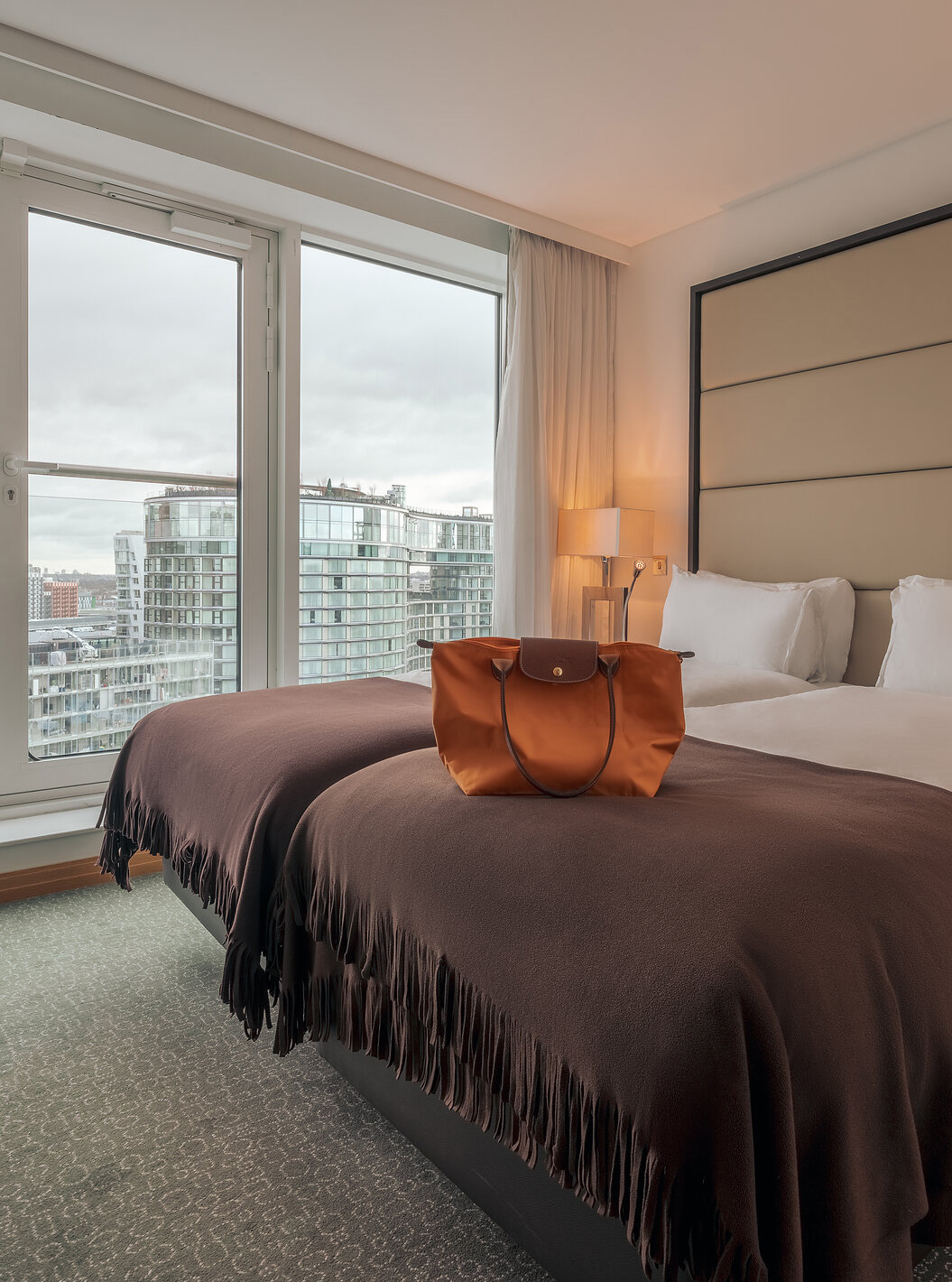 The Superior Twin at Pestana Chelsea Bridge has double bed, bedside tables, lamp and city view window