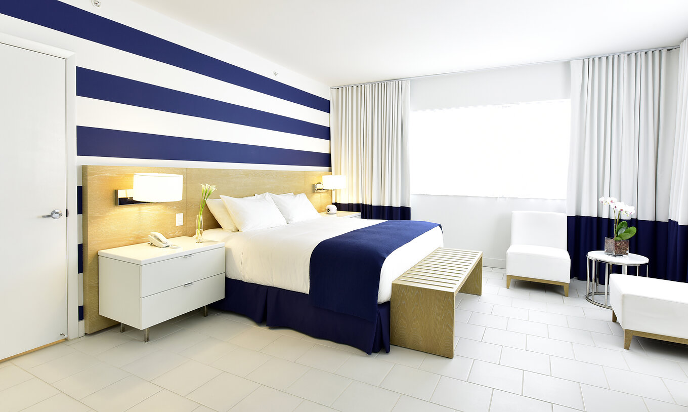 The Pestana Deluxe Queen - ADA Room at Pestana Miami South Beach has a double bed, lamp, table and two chairs