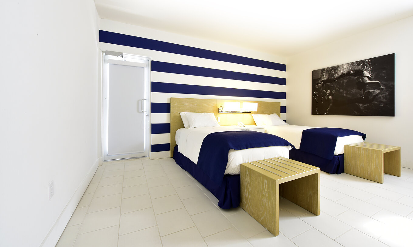 The Pestana Master Suite at Pestana Miami South Beach has two single beds and a lamp with bedside table