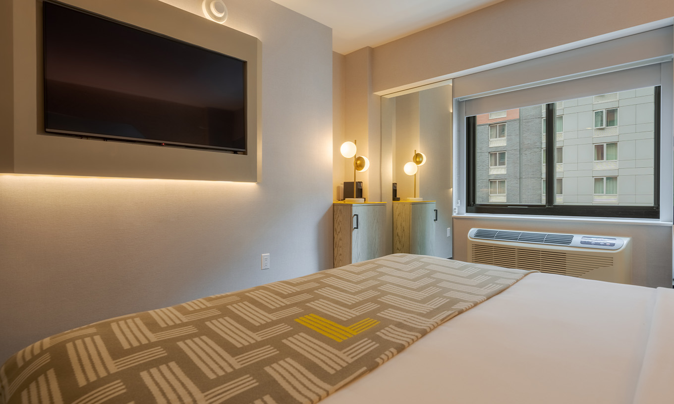 The Comfort at Pestana CR7 Times Square has a double bed with a bedspread with the number seven, a TV, and a window
