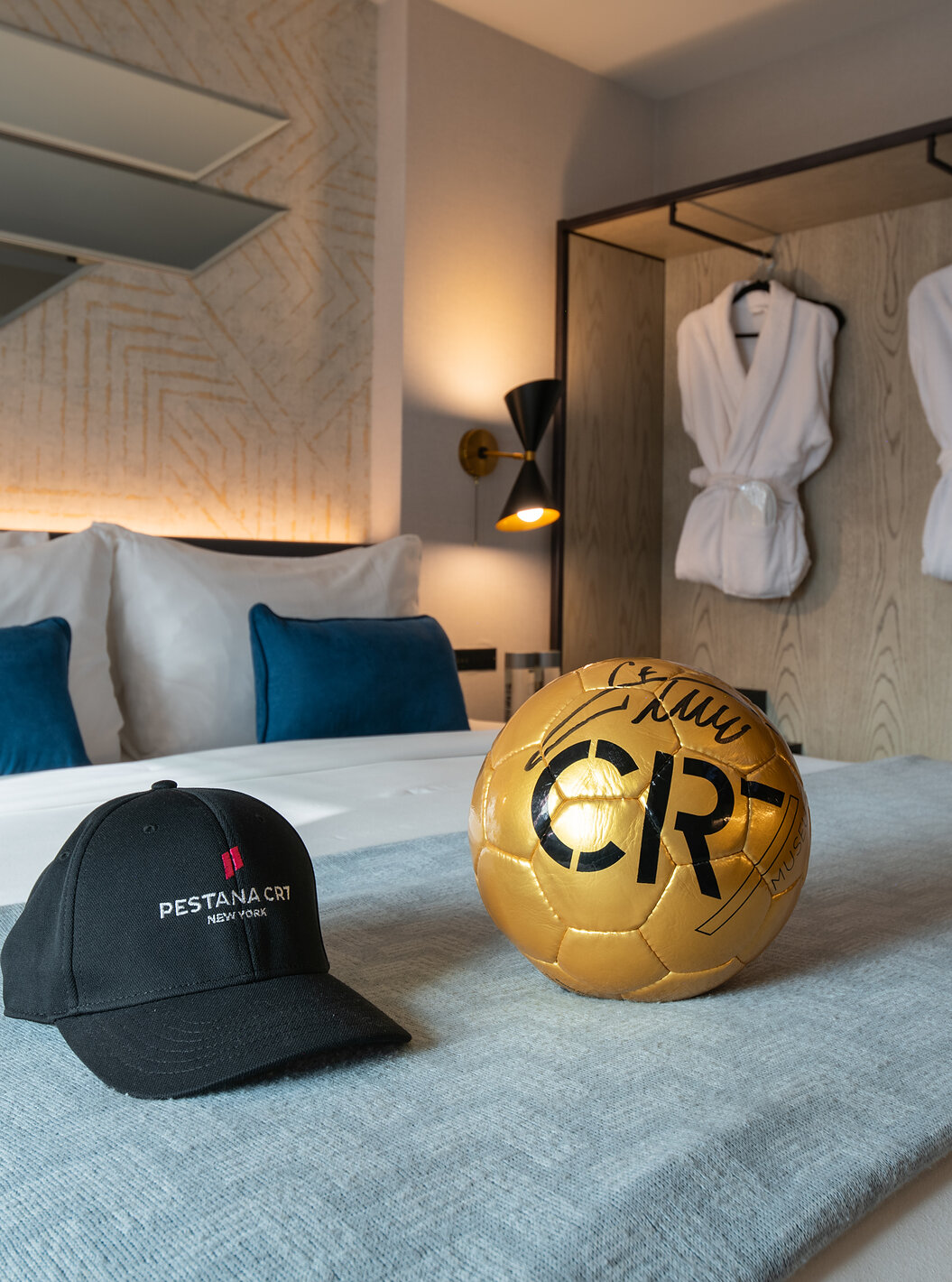 The Deluxe King Room at Pestana CR7 Times Square has a double bed with a CR7 ball and hat