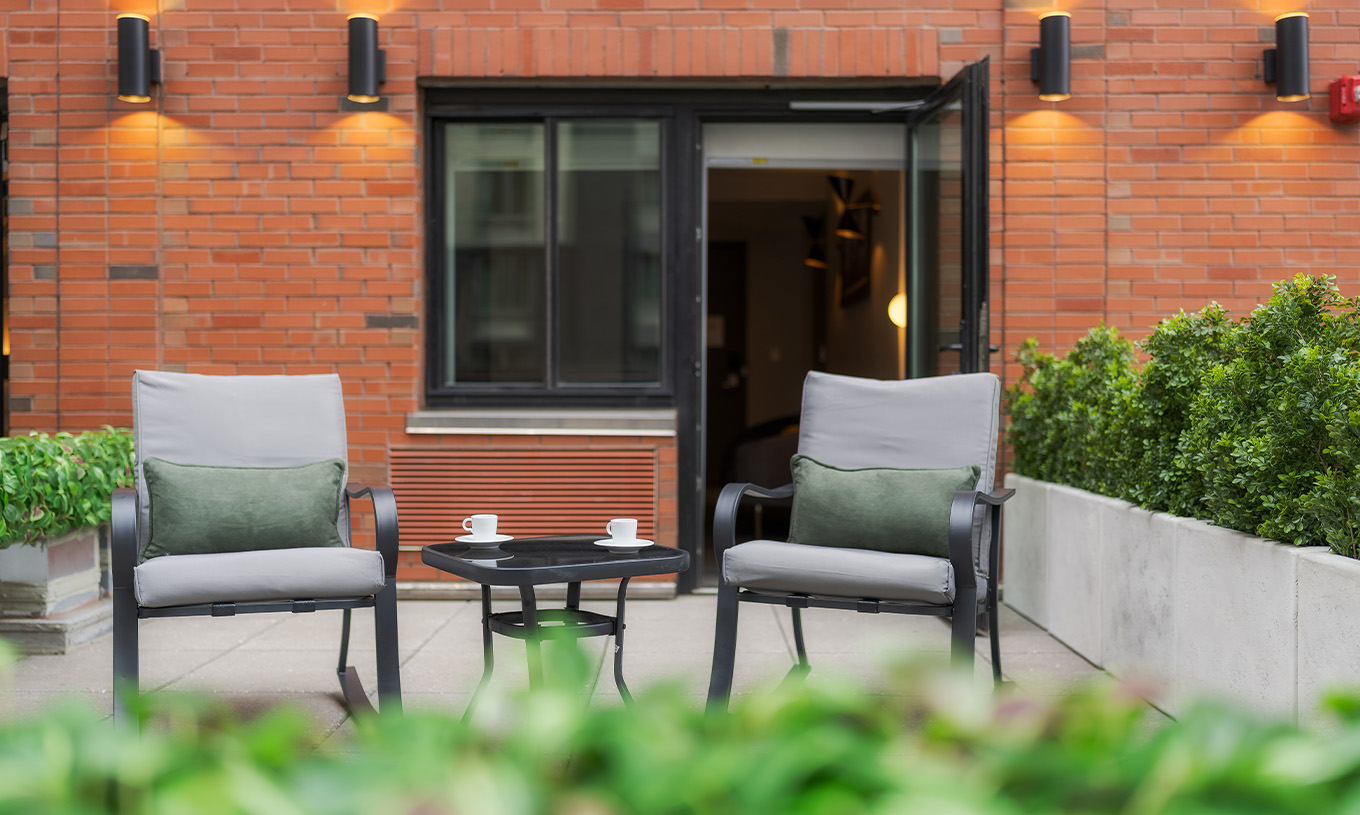 The ADA Junior Suite with Balcony and View at Pestana CR7 Times Square has a balcony with two chairs and a table