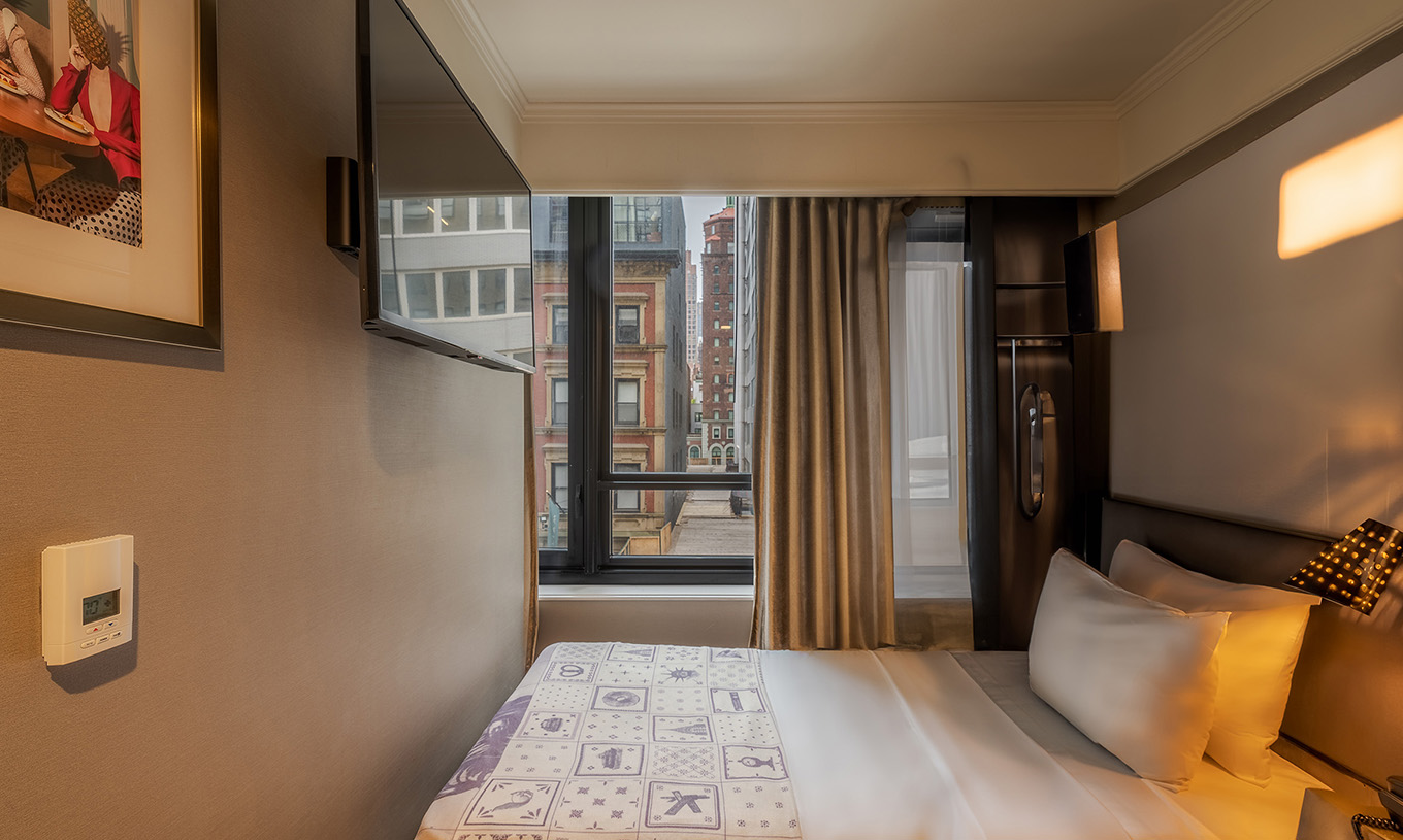 Cabin - ADA at Pestana Park Avenue has a double bed by the window and a television on the wall