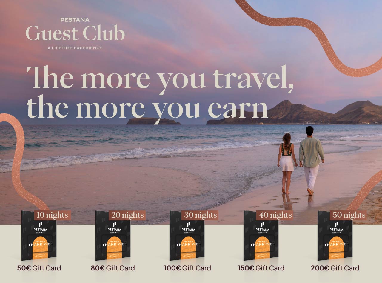 Couple walking along a beach at sunset beside ocean waves with travel rewards text and gift card offers