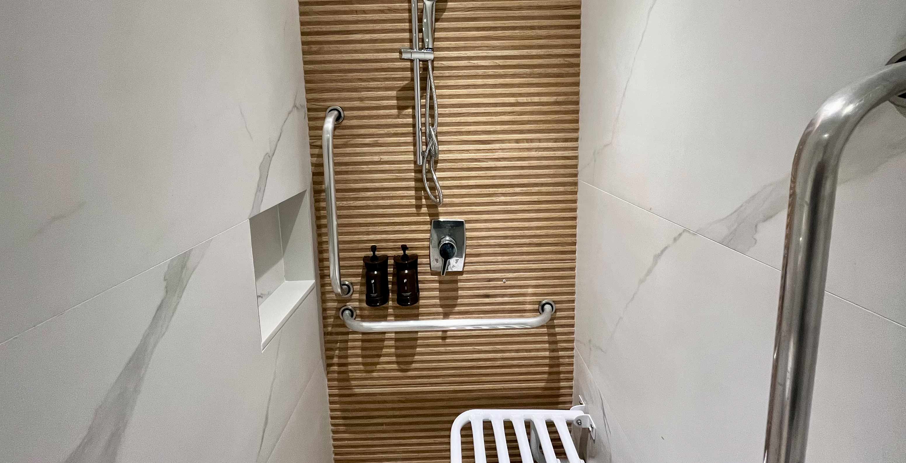 The Semi-Adapted Room at Pestana Rio Atlântica has a shower with grab bars, dispensers and a foldable seat