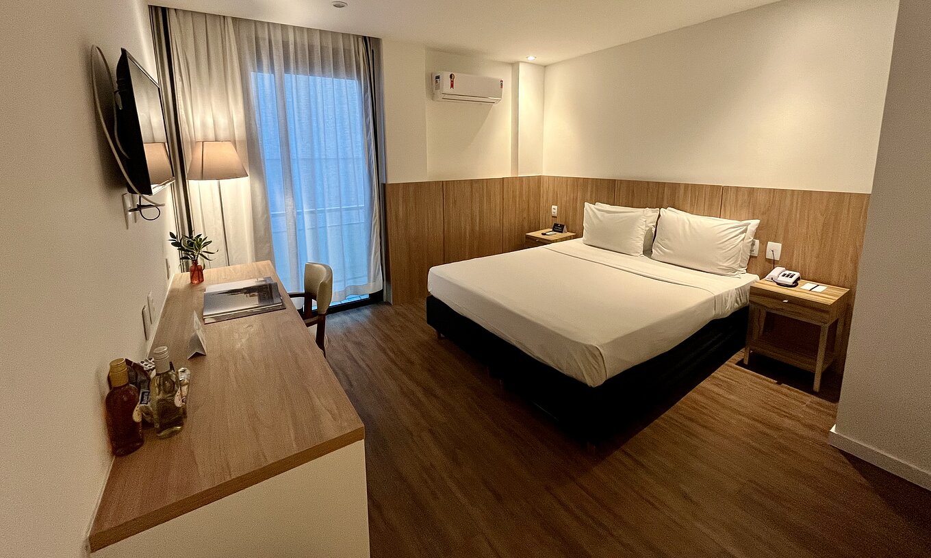 The Semi-Adapted Room at Pestana Rio Atlântica has a bed, desk, wall TV and wooden floor