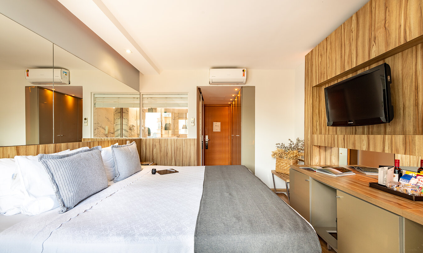 The Standard Double Room of Pestana Rio Atlântica has a double bed, mirror on the headboard, and a television in front