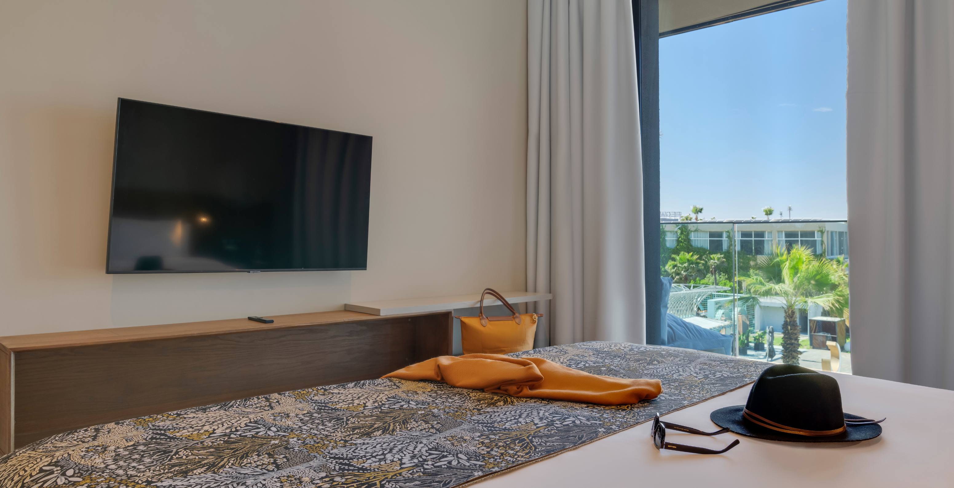 Family Suite at Pestana Casablanca with patterned bedspread, wall mounted TV and bright window view