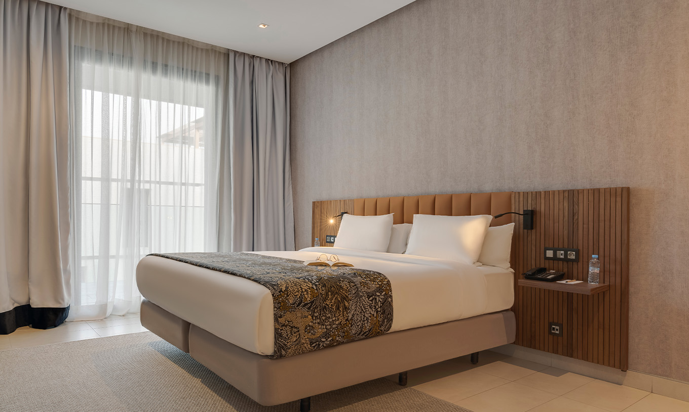 The Family Premium Superior Suite at Pestana Casablanca has a bedroom with a double bed and modern decor