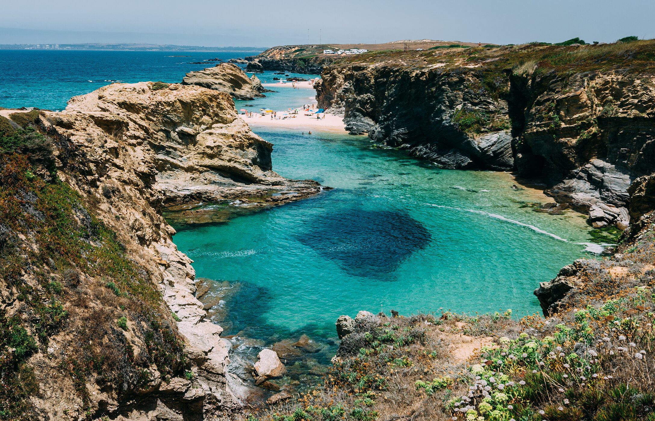 Paradise landscape of Praia da Samoqueira in Alentejo, hidden between cliffs and with crystal clear waters