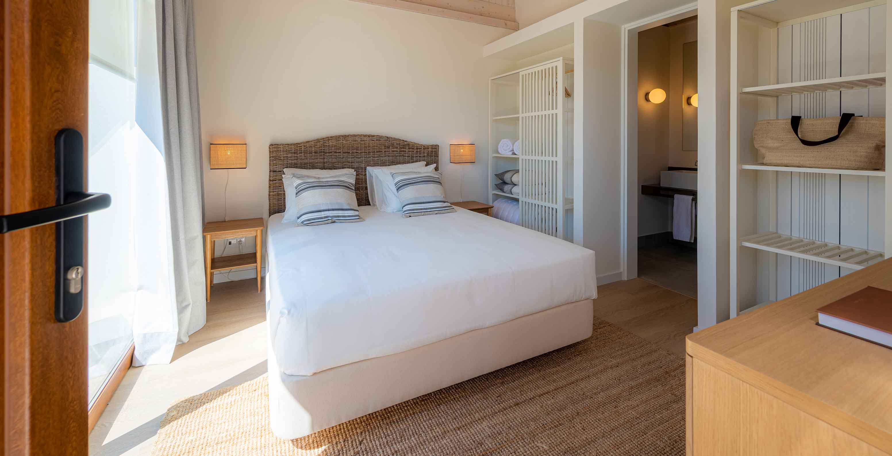 The Standard Villa T2 at Pestana Comporta Village Residences has a bedroom with a double bed and simple decor