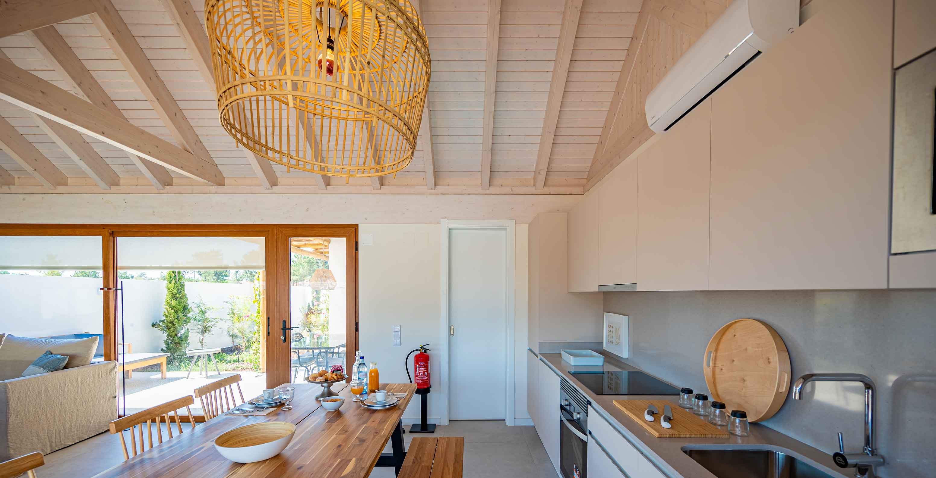 The Standard Villa T2 at Pestana Comporta Village Residences has a modern kitchen with a wooden table and an oven