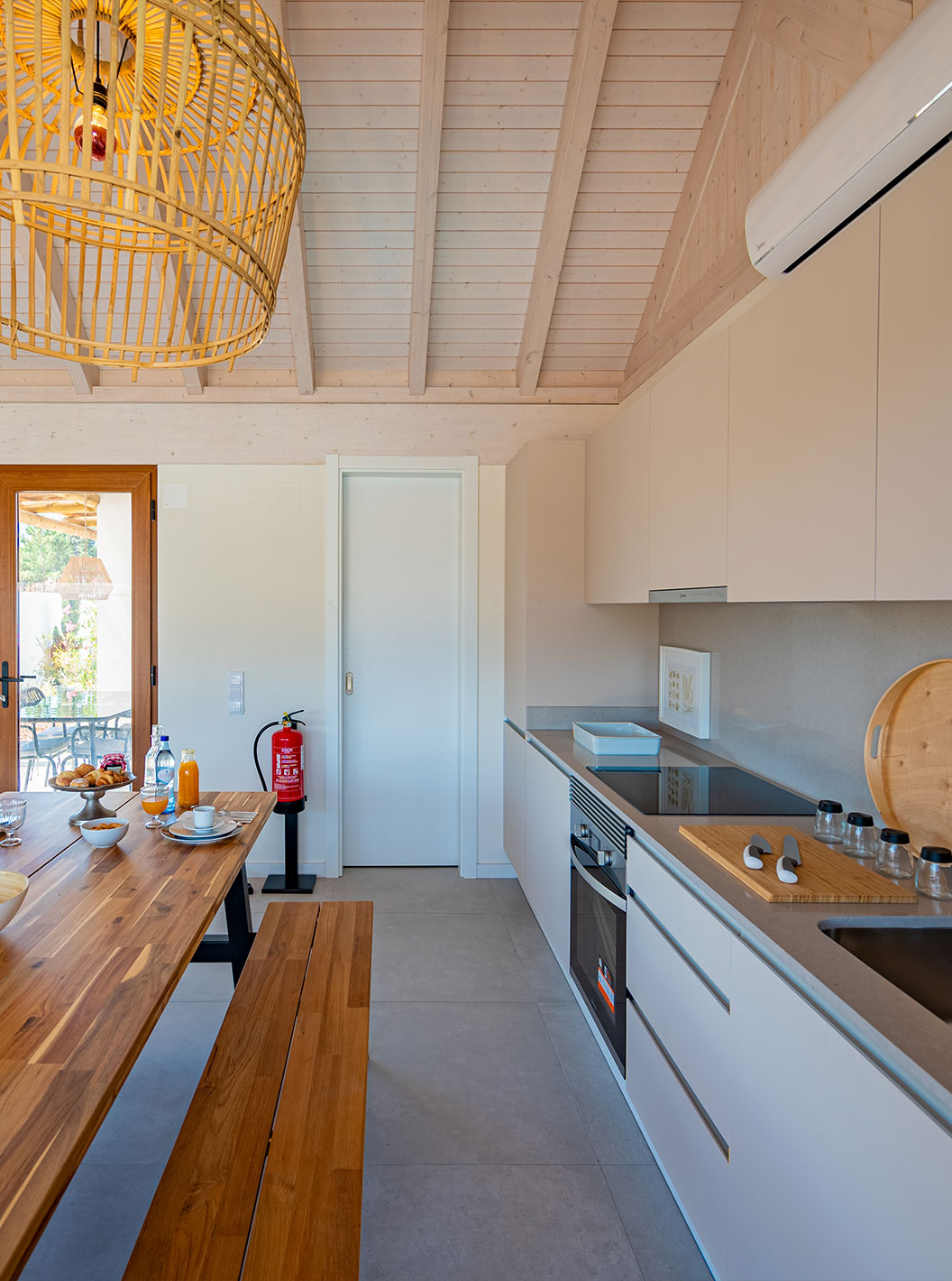 The Standard Villa T2 at Pestana Comporta Village Residences has a modern kitchen with a wooden table and an oven