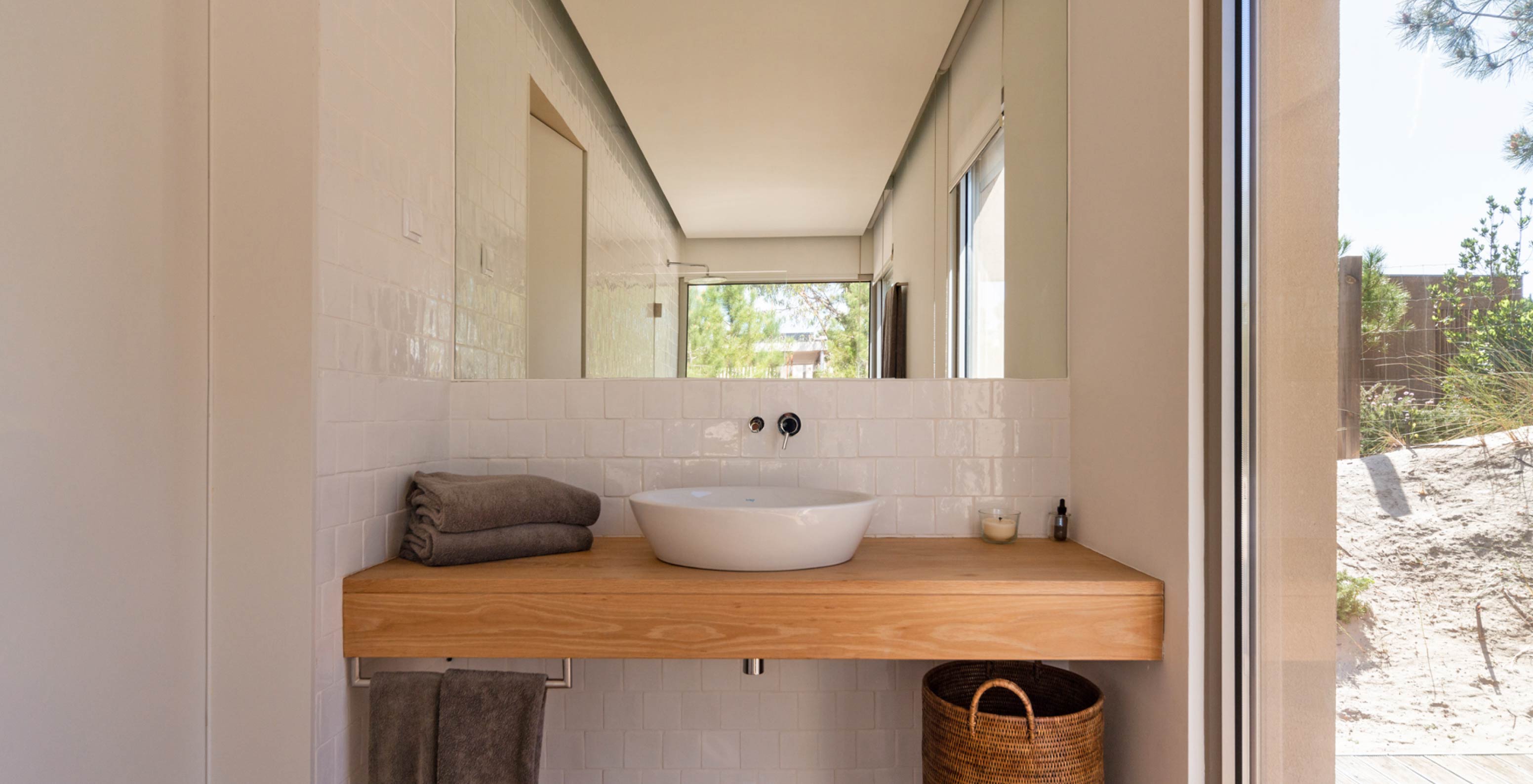 The exclusive villa with a pool at Pestana Tróia Eco Resort has a bathroom with a sink, a wooden counter, and a mirror