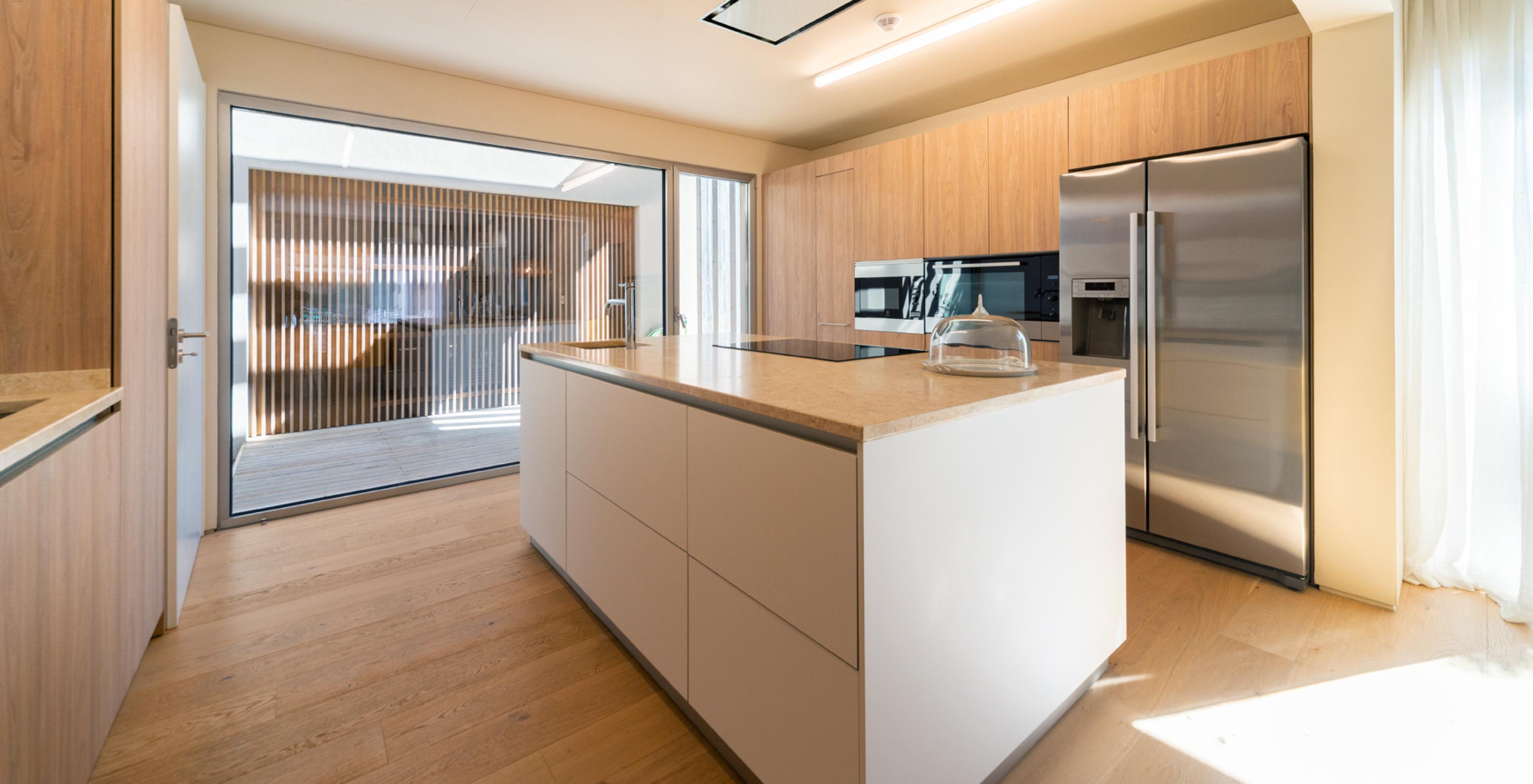 The exclusive villa with a pool at Pestana Tróia Eco Resort has a kitchen with wooden cabinets and a central island