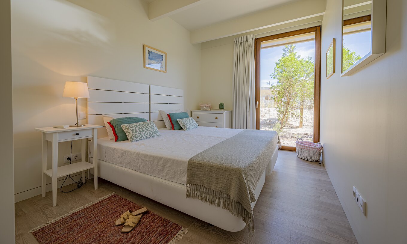 The Aqua Villa of Pestana Tróia Eco Resort has a double bed and a floor-to-ceiling window